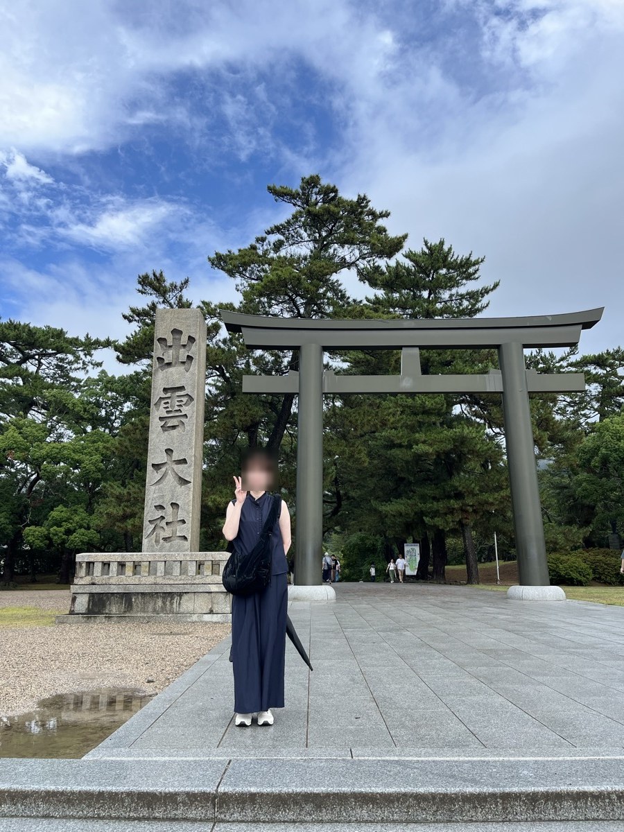 青空になった勢溜の鳥居と、出雲大社と刻まれた社号標。足元にはまだ水たまりが残っている