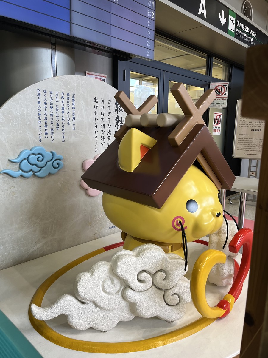 出雲縁結び空港の保安検査場の手前に立つ、しまねっこの像と縁結びの説明板