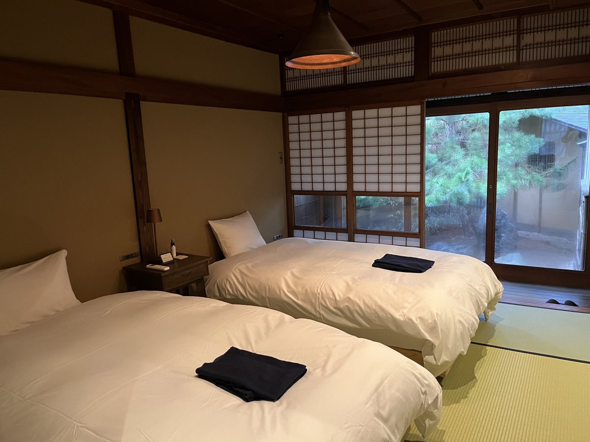 畳敷きの部屋にベッドが2つ並び、障子の向こうに庭が見える